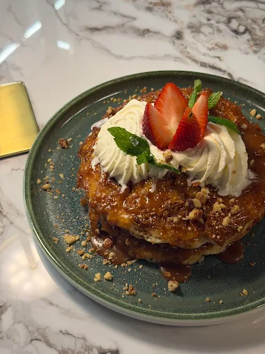 Caramel french toast with whipped cream and strawberries